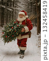 Santa carrying christmas tree through snowy forest 132458419