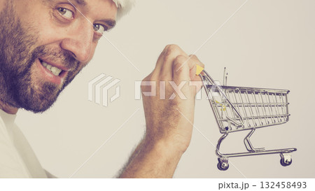 Man holding empty shopping cart Man holding empty shopping cart 132458493