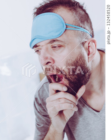 Sleepy man looking at mirror and yawning 132458520