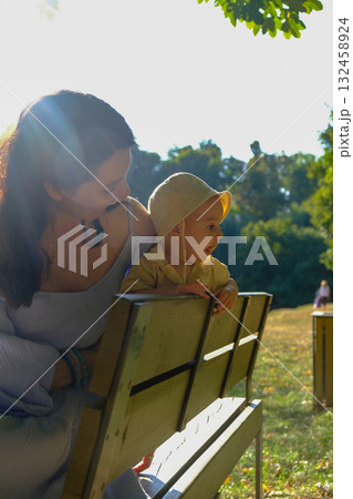 Mother and baby enjoying a sunny day in the park 132458924