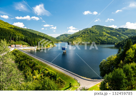 Panoramic view of the Sance reservoir and lake in summer, surrounded by green forests and blue sky, located near the Beskydy mountains in the Czech Republic. 132459785