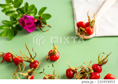 green background and harvest of red rose hips 132459953