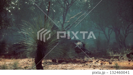 Lush greenery surrounds a mysterious creature partially hidden among the foliage during twilight hours. The tranquil setting evokes curiosity and wonder in natures realm. 132460041