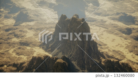 Towering rock formations rise majestically from a sandy terrain, illuminated by the soft glow of dawn. The vast expanse creates an enchanting atmosphere of solitude and mystery. 132460080