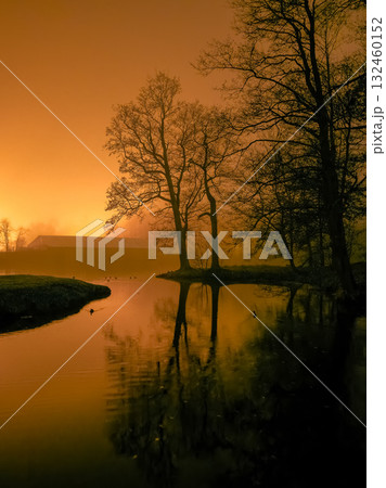 Dark silhouette of trees at sunset, reflection in water. Dark silhouette of trees at sunset, reflection in water. 132460152