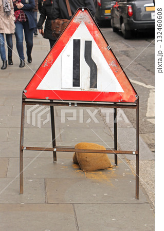 Narrowing street traffic sign on London sidewalk 132460608