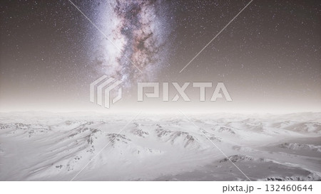 A breathtaking view of snow covered peaks extending under a vibrant Milky Way at night. The clear sky sparkles with countless stars, creating a magical winter landscape. 132460644