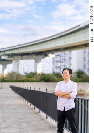 腕を組んで成功を確信する男性｜都市背景とコピースペース 132460710