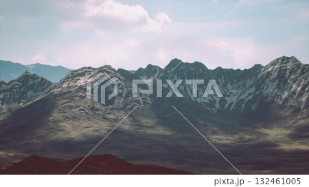 The rocky mountain range showcases snow covered peaks contrasting with the rocky slopes, set against a bright blue sky. A peaceful valley lies beneath, enhancing the natural beauty. The rocky mountain range showcases snow covered peaks contrasting with the rocky slopes, set against a bright blue sky. A peaceful valley lies beneath, enhancing the natural beauty. 132461005
