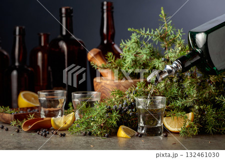 Gin is poured from a vintage bottle into a glass. Gin is poured from a vintage bottle into a glass. 132461030