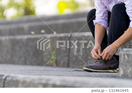 階段で靴紐を結ぶ男性 階段で靴紐を結ぶ男性 132461045