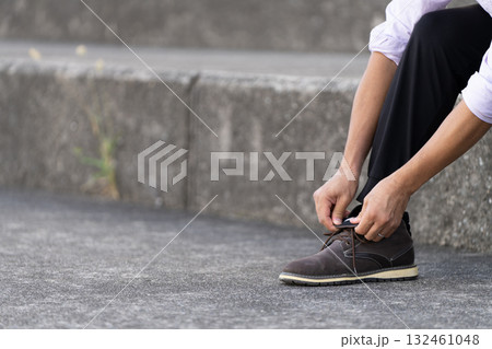 階段で靴紐を結ぶ男性 階段で靴紐を結ぶ男性 132461048