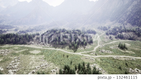 A breathtaking view of a mountainous region features lush green forests, rocky terrains, and winding paths beneath a clear sky. The area exudes tranquility and natural beauty. 132461115