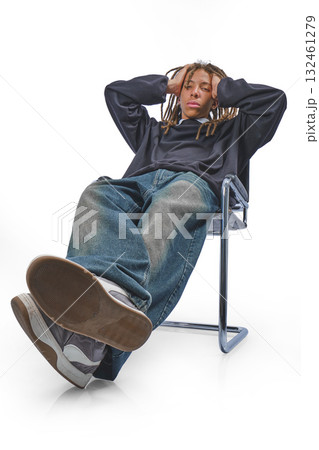 Young male slouching in a chair with arms crossed, reflecting youthful nonchalance Young male slouching in a chair with arms crossed, reflecting youthful nonchalance 132461279