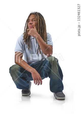 Young man with dreadlocks crouching, thinking on white 132461327