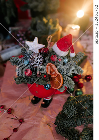 Winter Christmas bouquet in funny bowl on the table by the window.  132461752