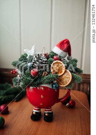 Winter Christmas bouquet in funny bowl on the table by the window. Winter Christmas bouquet in funny bowl on the table by the window. 132461754