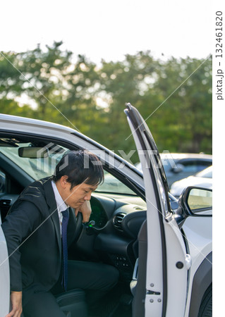ドアを開け車に乗り込むスーツの男性|出発のビジネスシーン ドアを開け車に乗り込むスーツの男性|出発のビジネスシーン 132461820