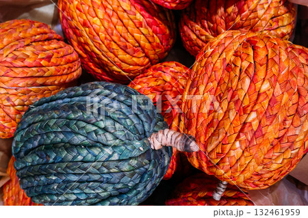 Colorful woven pumpkins made from braided natural fibers in shades of orange and teal. Eco-friendly seasonal decor, sustainable craftsmanship, autumn home styling, plastic-free holidays Colorful woven pumpkins made from braided natural fibers in shades of orange and teal. Eco-friendly seasonal decor, sustainable craftsmanship, autumn home styling, plastic-free holidays 132461959
