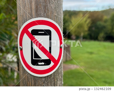 No cell phone sign is on a wooden pole No cell phone sign is on a wooden pole 132462109