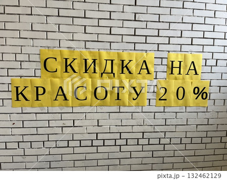 Bright yellow promotional signs displaying a 20% discount on beauty services, arranged on a textured white brick wall, creating an eye-catching advertisement for customers Bright yellow promotional signs displaying a 20% discount on beauty services, arranged on a textured white brick wall, creating an eye-catching advertisement for customers 132462129