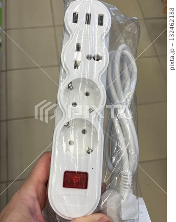 White power strip with multiple outlets and USB ports, featuring a red power indicator, designed for home and office use, showcasing modern electrical convenience 132462188