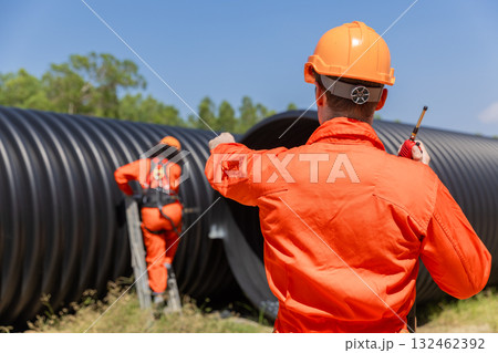ndustry Engineers Walking Inside Circular water Pipe. Engineering or Worker inspection pipe  132462392