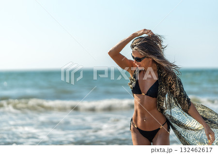 Beachside thoughtful portrait, Serene woman with flowing shawl, Contemplative woman stands at seaside with graceful Beachside thoughtful portrait, Serene woman with flowing shawl, Contemplative woman stands at seaside with graceful 132462617