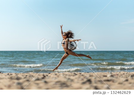 Graceful ballerina dance, Elegant leap by seaside dancer, Poised ballet performer executing graceful jump along coast Graceful ballerina dance, Elegant leap by seaside dancer, Poised ballet performer executing graceful jump along coast 132462629