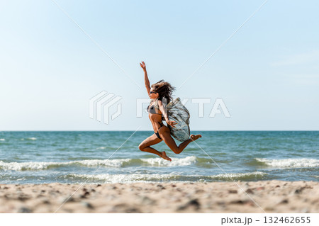 Sunny beach with joyful motion, Joyful woman runs along warm coast, Energetic woman dances on sunlit sandy shoreline Sunny beach with joyful motion, Joyful woman runs along warm coast, Energetic woman dances on sunlit sandy shoreline 132462655