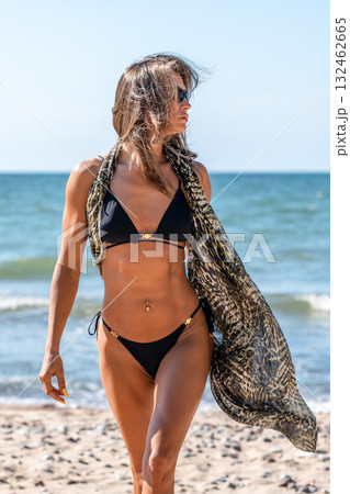 Confident lady displaying strong abdominal muscles, Active woman at seaside demonstrating fit and healthy physique Confident lady displaying strong abdominal muscles, Active woman at seaside demonstrating fit and healthy physique 132462665