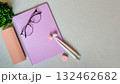 Notebook on light gray background with pens and erasers. Glasses with case. Flower 132462682