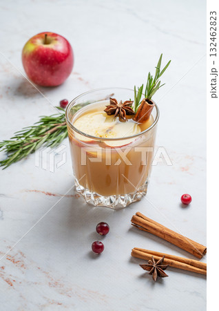 Hot apple cider with cinnamon, anise, and rosemary in glass on a marble background with cranberry Hot apple cider with cinnamon, anise, and rosemary in glass on a marble background with cranberry 132462823
