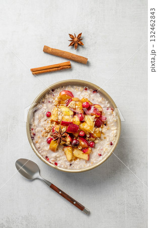 Overnight oatmeal with apple, cranberry and cinnamon in a plate on a light background with spice Overnight oatmeal with apple, cranberry and cinnamon in a plate on a light background with spice 132462843