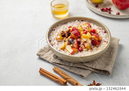 Overnight oatmeal with apple, cranberry, honey and cinnamon in a plate on a light background Overnight oatmeal with apple, cranberry, honey and cinnamon in a plate on a light background 132462844