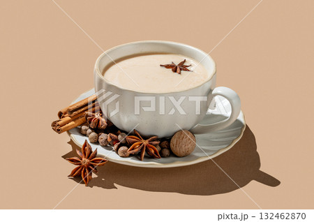 Traditional Indian masala chai tea with milk and spices in a cup on a beige background 132462870