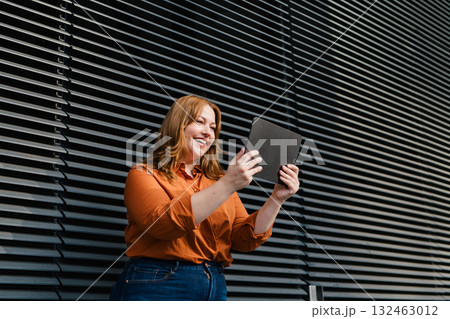 Plus size woman holding tablet, black background. Plus size woman holding tablet, black background. 132463012