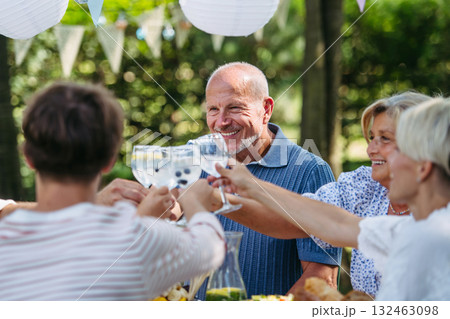 Multigenerational family toasting during outdoor barbecue party. Multigenerational family toasting during outdoor barbecue party. 132463098
