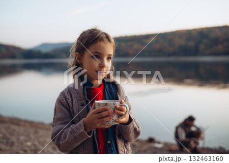 Girl in autumn nature drinking hot tea. 132463160
