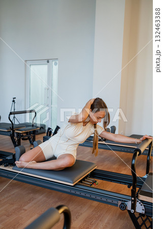 Woman doing mermaid exercise in a sunlite modern studio, embodying calm, focus, and strength. 132463388