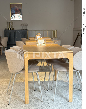 Minimal wooden tables and chairs in bright cafe interior. Scandinavian design, soft lighting, and cozy modern atmosphere. 132463668