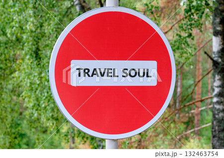 A red circle sign with a white rectangle in the middle displays the words TRAVEL SOUL. Lush green foliage in the background suggests a vibrant forest setting, inviting exploration 132463754