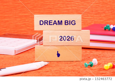Colorful wooden blocks display the words dream big and the year 2026 against a bright orange backdrop Colorful wooden blocks display the words dream big and the year 2026 against a bright orange backdrop 132463772