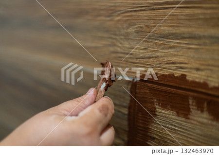 A worker carefully applies grout to fill the joints between new ceramic wall tiles, ensuring a smooth and finished surface during a home renovation. Filling the joints between tiles with grout. 132463970