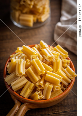 Cinque buchi. Uncooked italian pasta in bowl on wooden table. Cinque buchi. Uncooked italian pasta in bowl on wooden table. 132464717