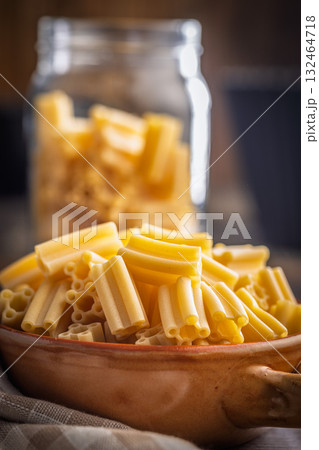 Cinque buchi. Uncooked italian pasta in bowl on wooden table. 132464718