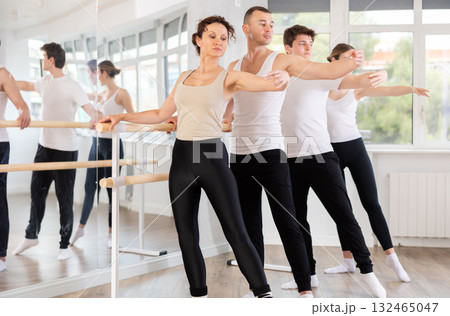 Group of dancers doing batman tandu jete at barre Group of dancers doing batman tandu jete at barre 132465047