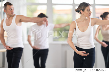 Woman leading ballet class with amateur dancers in studio 132465079