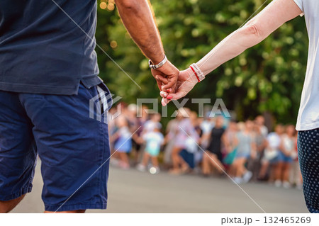 Close-up of couple holding hands during traditional Bulgarian horo dance at public event. Concept of unity in culture, Bulgarian tradition, emotional connection, national folk dance Close-up of couple holding hands during traditional Bulgarian horo dance at public event. Concept of unity in culture, Bulgarian tradition, emotional connection, national folk dance 132465269