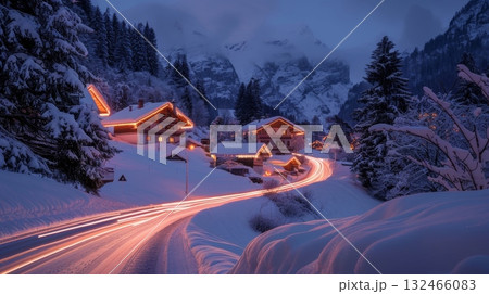 A magical winter scene with the soft glow of car light trails leading to inviting mountain chalets 132466083